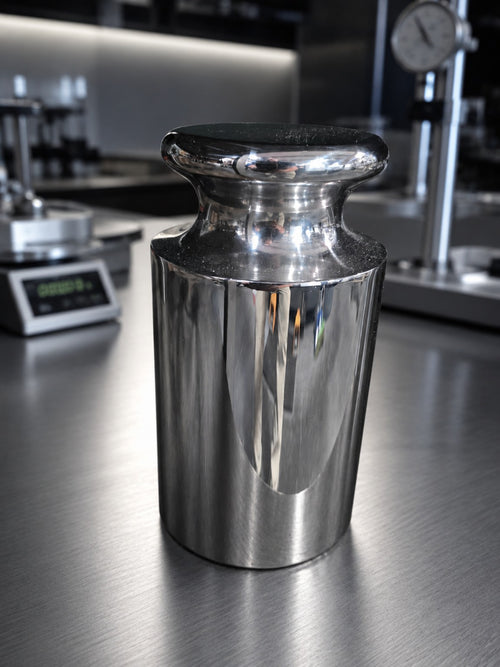 Representative polished cylindrical calibration weight in an INSCO laboratory; see product specifications for nominal mass.